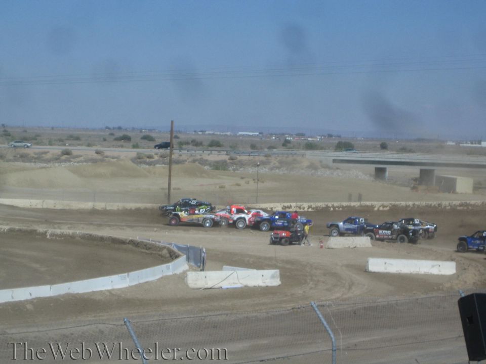 Group of off-road race trucks grouped together on a dirt racing course
