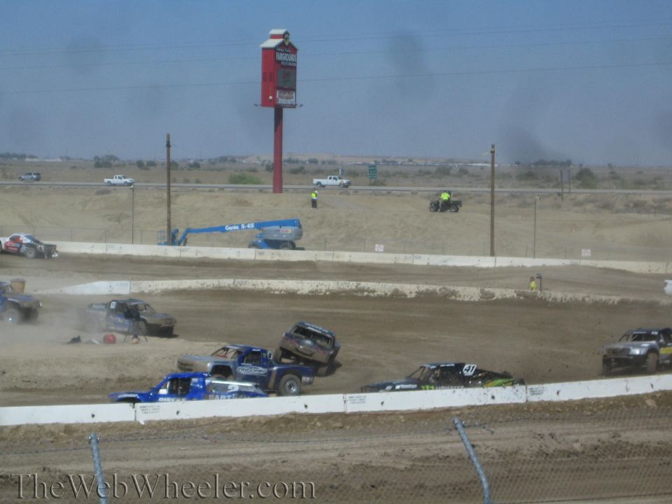 Off-road race trucks racing and kicking up dust on a dirt track