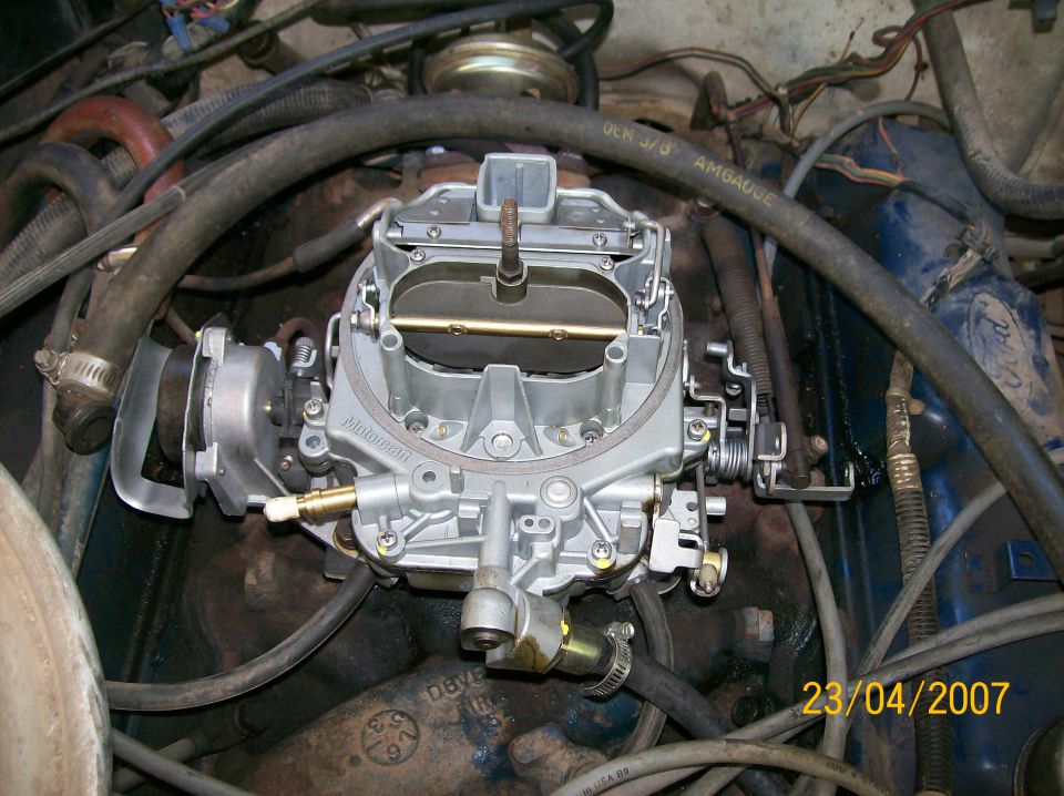 Close-up of a Motorcraft carburetor in an engine bay with hoses and wiring
