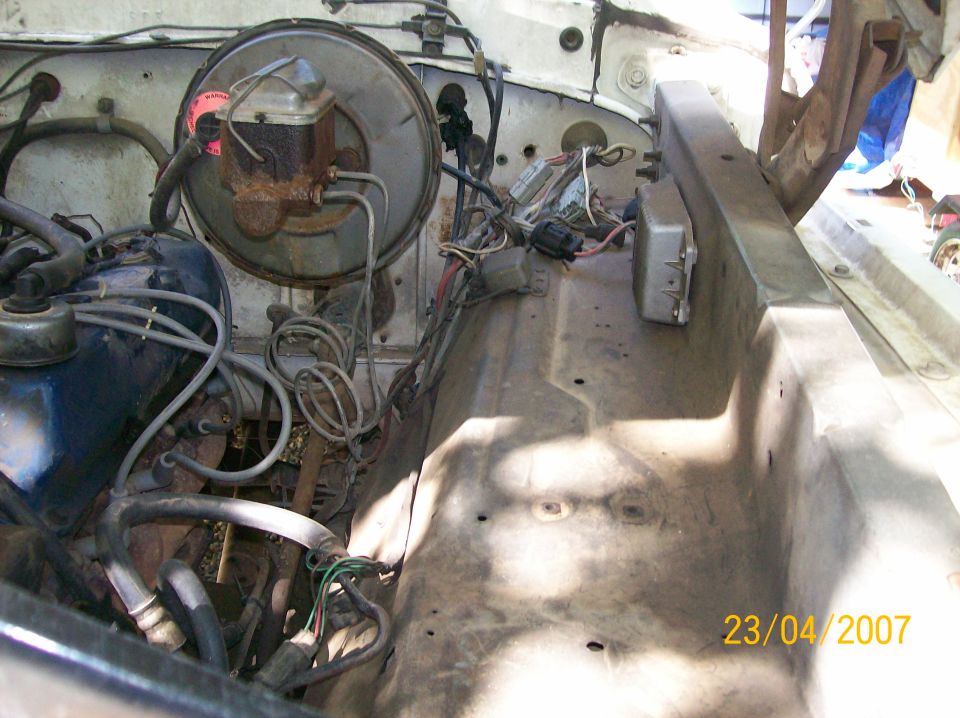 Engine bay with brake booster, master cylinder, and wiring visible