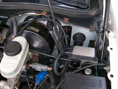 1999 Ford Crown Victoria - Close-up view of the engine bay, focusing on the brake booster and master cylinder assembly.