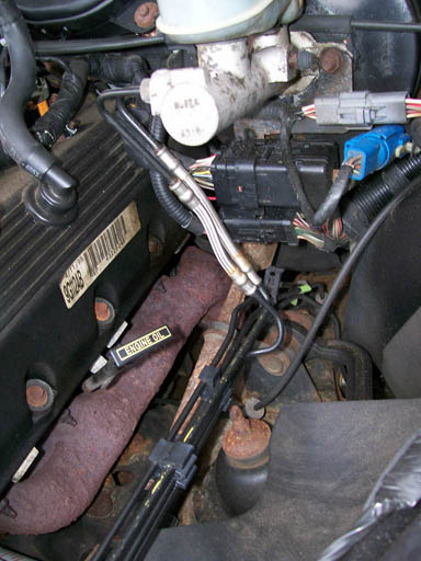 1999 Ford Crown Victoria - Close-up of an engine bay, focusing on the brake fluid reservoir and various electrical connections.