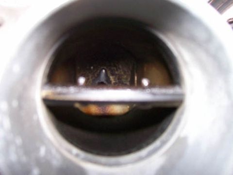 1999 Ford Crown Victoria - Close-up view inside a throttle body, showing the butterfly valve mechanism.