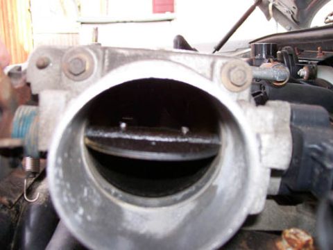 1999 Ford Crown Victoria - Throttle body interior showing carbon buildup around the butterfly valve.