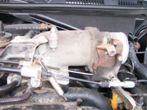 1999 Ford Crown Victoria - Throttle body assembly from a vehicle's engine compartment.