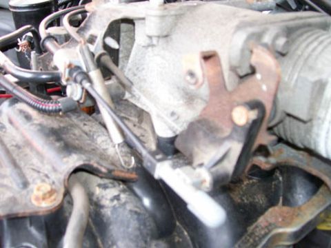 1999 Ford Crown Victoria - This image shows a close-up view of an engine's throttle linkage mechanism.
