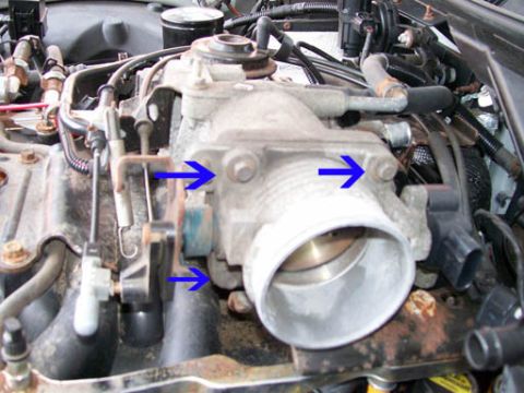1999 Ford Crown Victoria - Close-up of a vehicle's throttle body assembly, with arrows indicating mounting points.