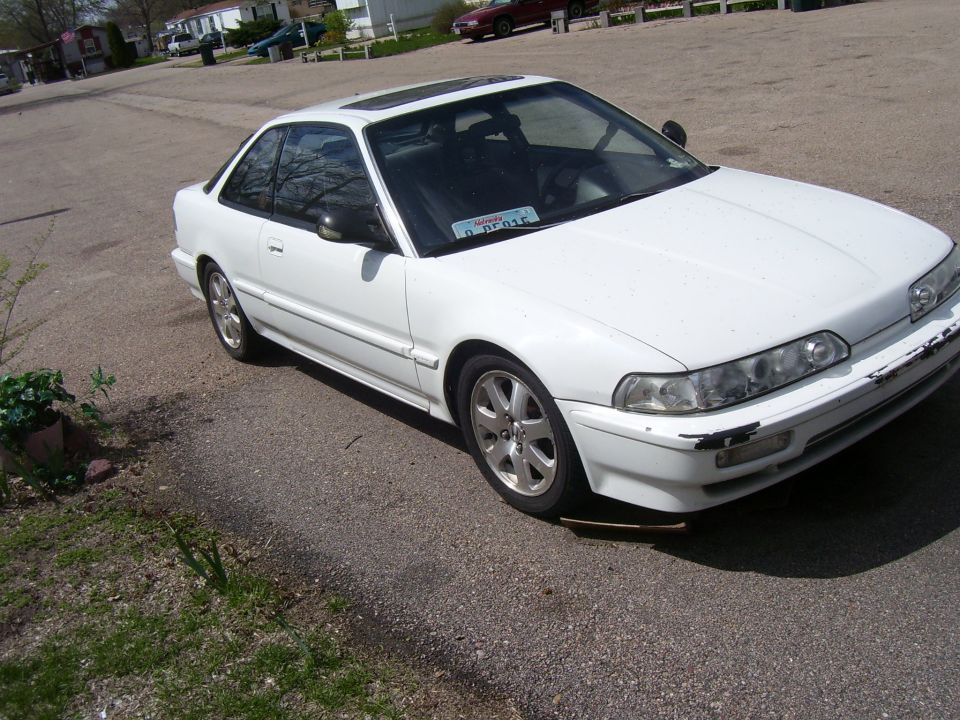 White coupe with sunroof and aftermarket wheels. License plate reads D PF015