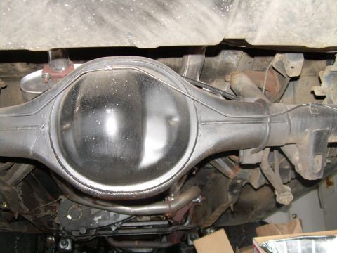 1984 Ford Bronco - Underside view of a rear axle housing and differential with exhaust pipes visible.