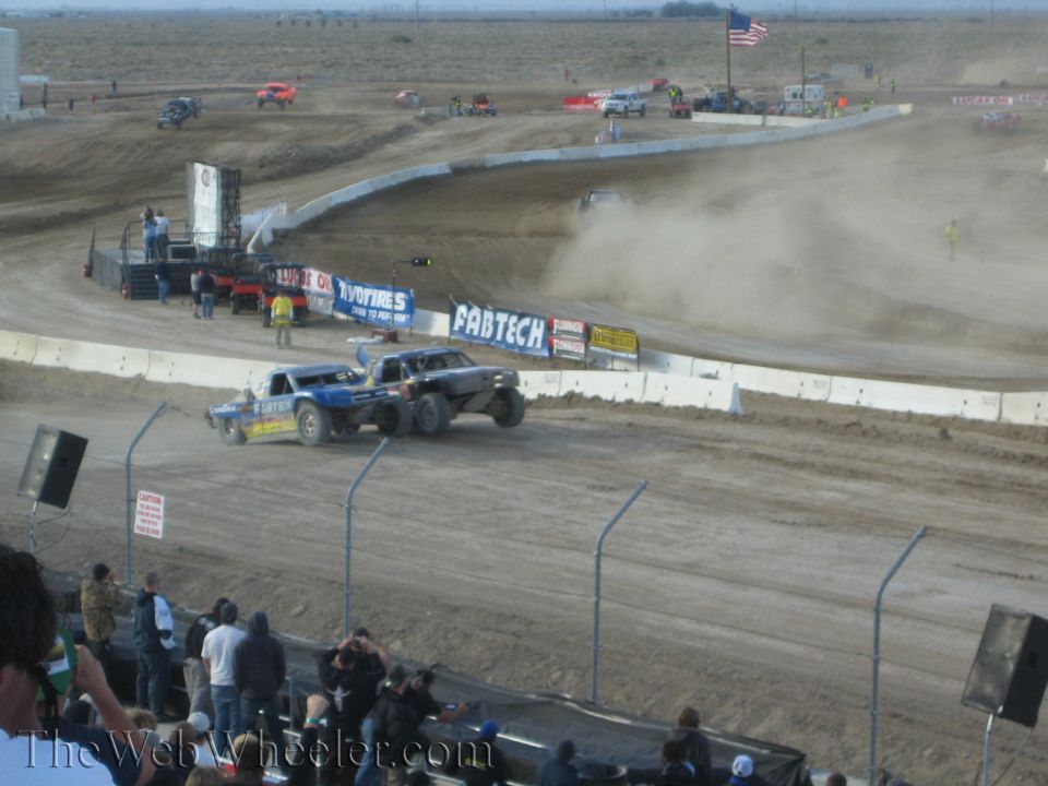 Blue off-road race truck on a dusty dirt track