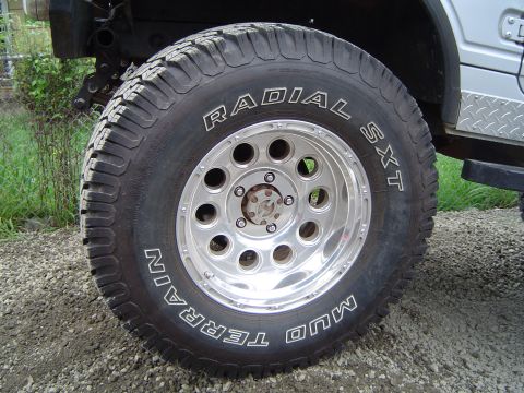 1989 Ford Bronco - This photo shows a close-up of an off-road tire and wheel assembly, with visible text indicating its type and brand.