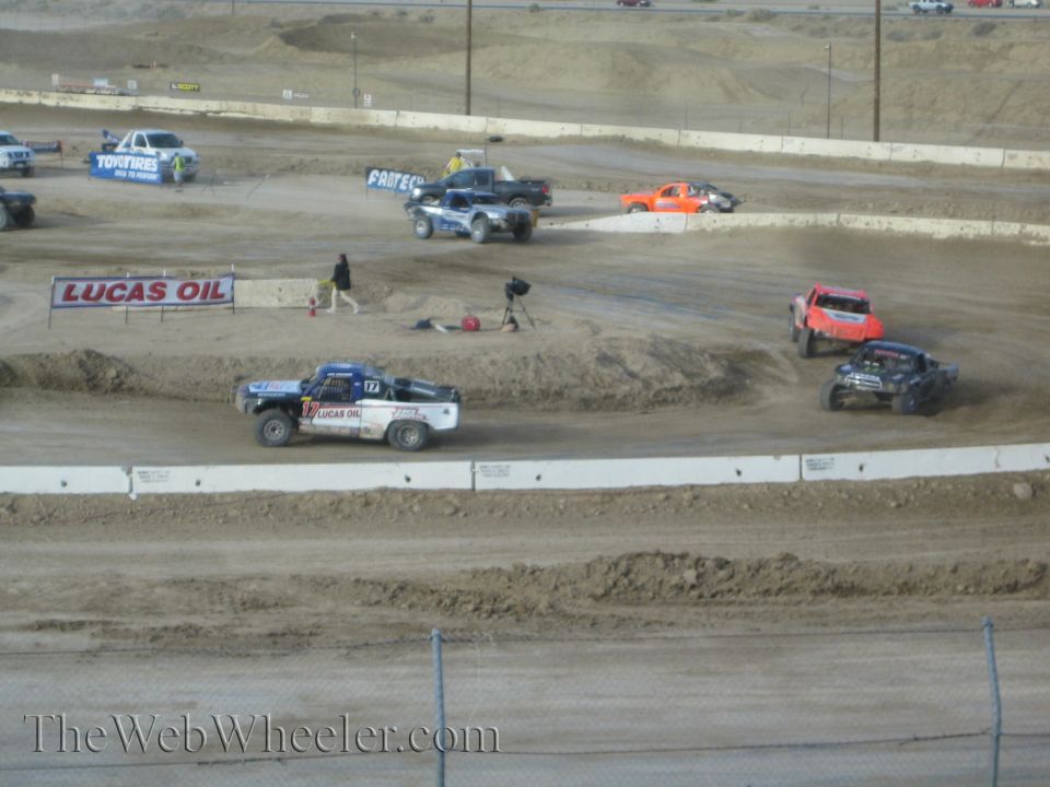 Field of off-road race trucks on a dirt short-course track