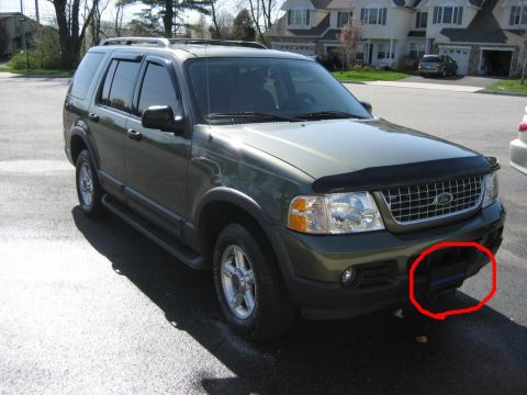 1998 Ford Crown Victoria - Green Ford Explorer SUV parked on asphalt, front view. Red circle highlights part of the front bumper.