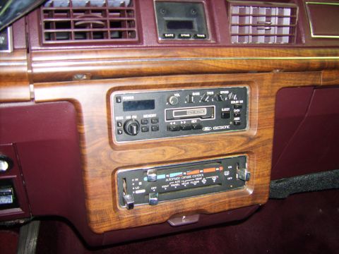 1982 Ford LTD Crown Victoria - Close-up of a burgundy interior center dash with woodgrain trim, showing a Ford Electronic AM/FM cassette radio with seek, memory, Dolby NR…