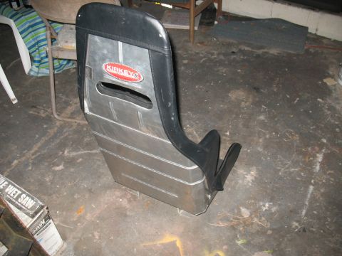 1985 Ford Crown Victoria LTD - A Kirkey racing seat sits on a concrete floor next to a box for a wet saw.