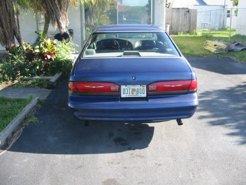 1995 Ford Thunderbird - Rear view of a blue sedan with a Florida license plate, parked outdoors.