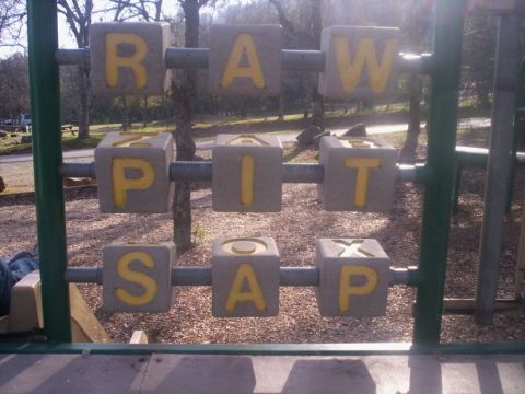 1989 Ford Bronco - Alphabet blocks on a playground spell out 'RAW PIT SAP' in yellow letters.
