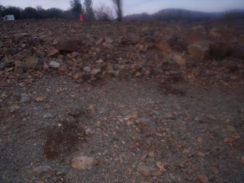 1989 Ford Bronco - A white trailer is visible in the distance on a rocky, uneven landscape under a dim sky.