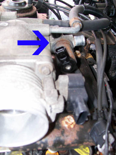 1999 Ford Crown Victoria - Close-up of an engine component, with a blue arrow indicating a specific sensor.