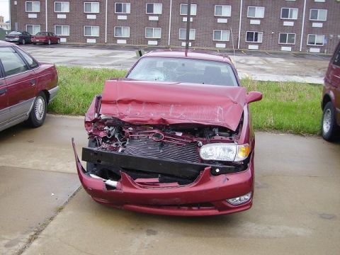 1996 Ford F-350 - This red sedan sustained significant damage to its front end, with the hood and grille heavily impacted.