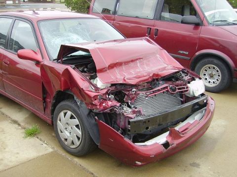 1996 Ford F-350 - This red sedan sustained significant damage to its front end, including a caved-in hood and shattered windshield.