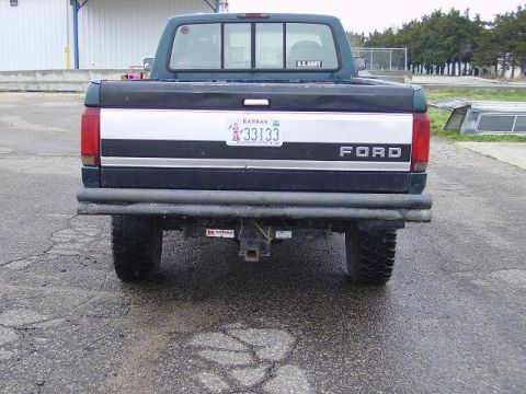 1996 Ford F-350 - The rear of a dark blue Ford F-350 pickup truck is visible, showing its tailgate and license plate.