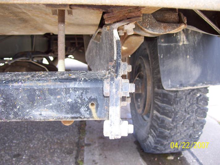 Close-up of a metal bracket attached to a truck frame near the rear tire