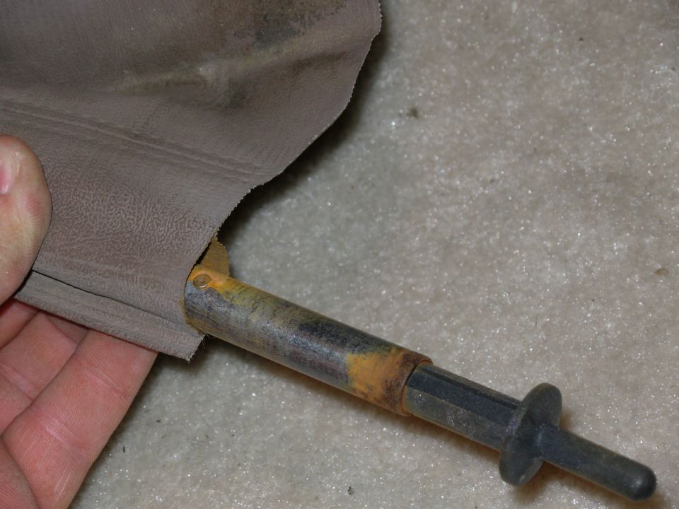 Slide the draw rod far enough to expose one rivet, and turn it to the flared end.  Use a small file to remove the flare, compress the catch pin slightly, and drive the rivet out using a 3/32" drift.  DO NOT DRILL and don't remove the 2nd rivet.