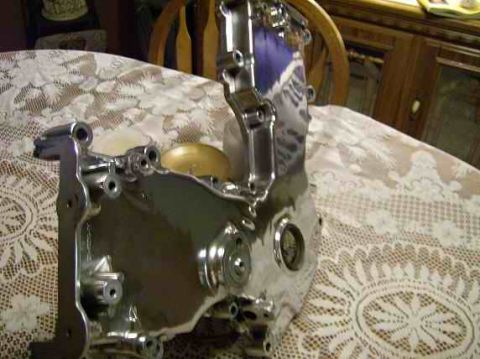 1978 Ford Mustang II - Shiny chrome engine component with visible bolt holes and circular recesses.