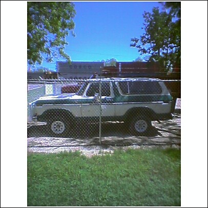 1979 Ford Bronco - This two-tone Ford Bronco is seen parked outdoors behind a fence on a sunny day.