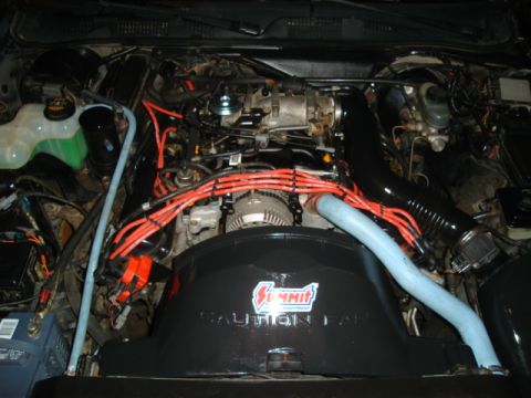 1992 Ford Crown Victoria - Engine bay view showing red spark plug wires and a Summit Equipment fan shroud. The registry claims this is a 1992 Ford Crown Victoria.