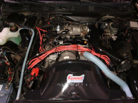1992 Ford Crown Victoria - Engine bay of a 1992 Ford Crown Victoria, a Summit Racing air intake and red spark plug wires.
