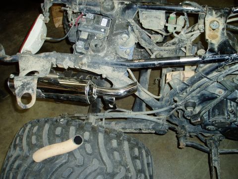 2000 Ford E350 - Close-up view of an ATV's exhaust pipe and rear tire, showing mechanical components.