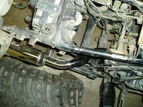 2000 Ford E350 - Close-up view of a chrome exhaust pipe and the frame of an ATV.