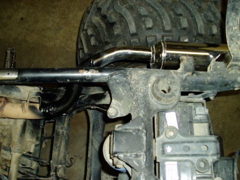 2000 Ford E350 - Detail of a vehicle's exhaust system and frame, showing a chrome pipe and part of a tire.