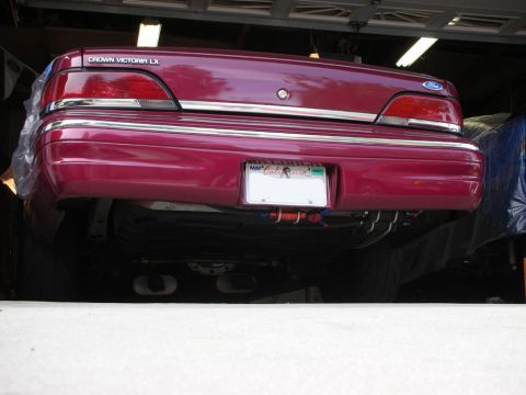 1992 Ford Crown Victoria - The rear of a maroon Ford Crown Victoria LX is shown, with its distinctive taillights and chrome accents.