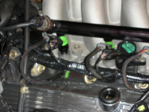 1992 Ford Crown Victoria - Close-up view of engine fuel injectors and fuel rail during a rebuild or preparation process.