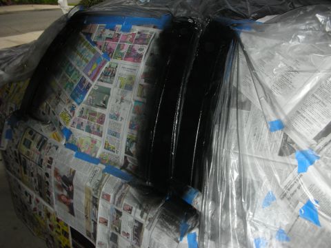 1992 Ford Crown Victoria - A car is being prepped for painting, with newspaper and plastic covering the windows and body panels.