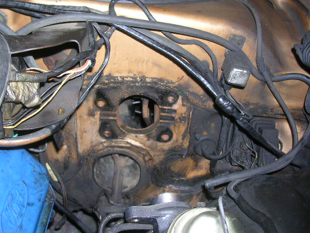 Close-up of a vehicle's firewall with wiring and components visible