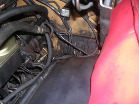 1975 Ford Ranchero - A view of various engine bay parts, including hoses and wiring, with a prominent red component on the right.