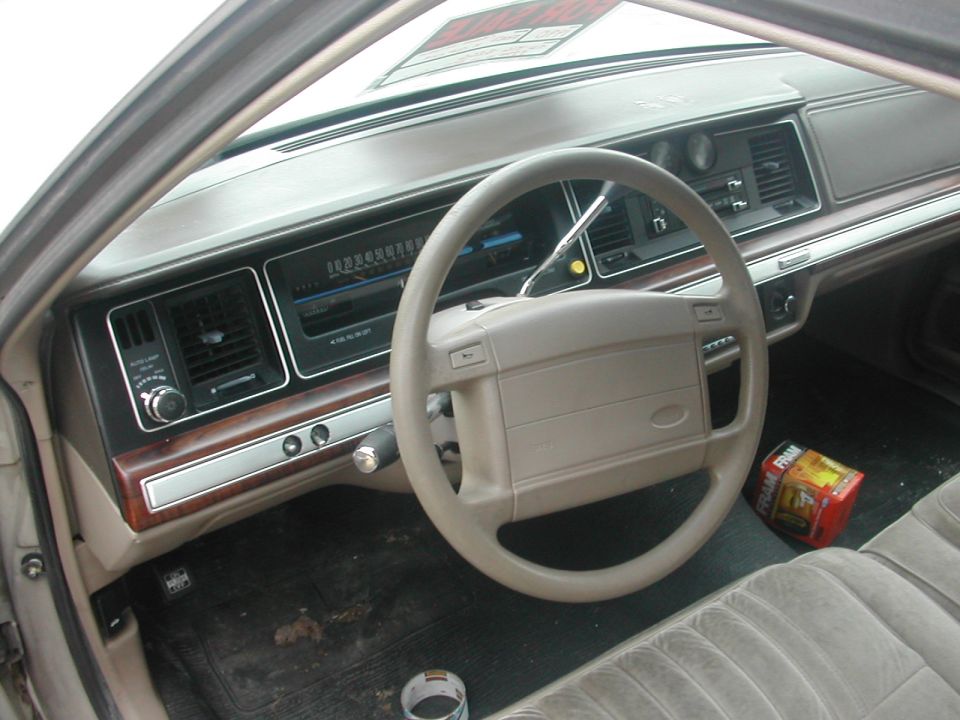 Tan Ford sedan interior dashboard and steering wheel