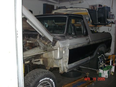 1979 Ford Bronco - This Ford Bronco is in a garage with its hood up, possibly being worked on. Another vehicle is parked behind it.