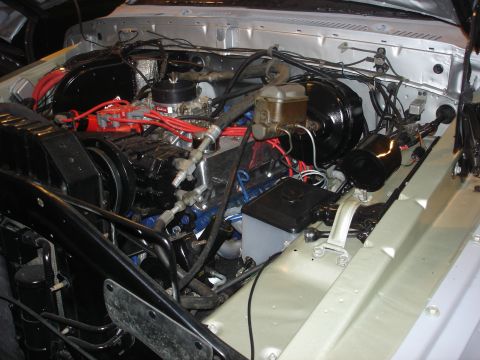 1979 Ford Bronco - Close-up view of the engine bay, showing the V8 engine, carburetor, and brake booster assembly.