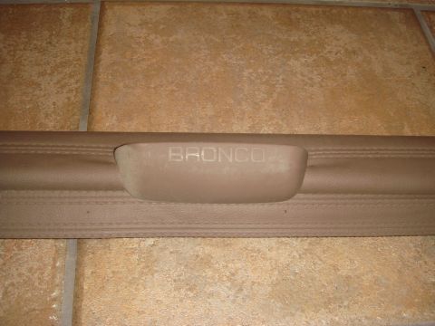 1996 Ford Bronco - Close-up of a tan interior trim piece with the word "BRONCO" embossed into the handle area.