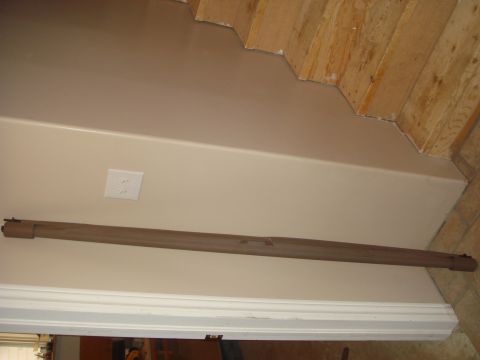 1996 Ford Bronco - A rolled-up cargo cover is shown leaning against a wall, with unfinished wooden stairs visible above.
