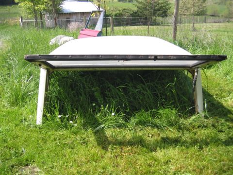1968 Ford Bronco - A white hardtop is shown from the rear, supported by wooden legs in a grassy field.