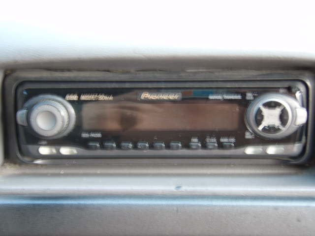 Pioneer car stereo head unit in gray dashboard with two knobs and button row