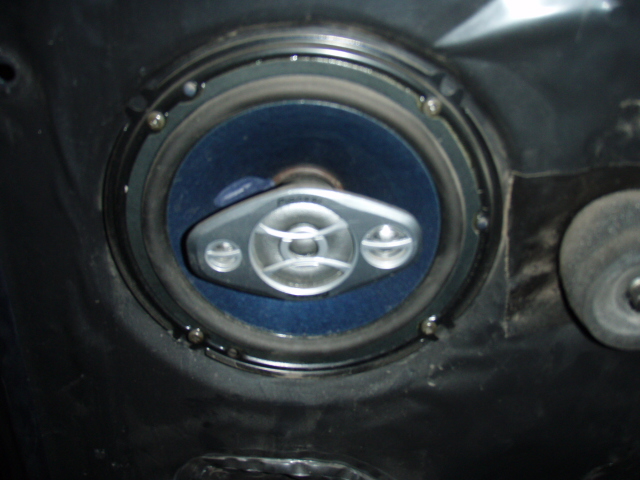 Aftermarket 6x9 speaker with blue cone and silver tweeters mounted in a black door panel