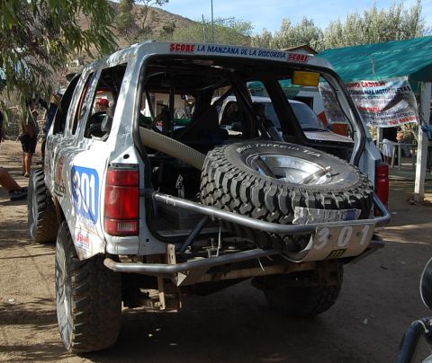 1992 Ford Explorer - This off-road race truck features a prominent spare tire mounted on the rear bumper and the number 301 displayed on its side.