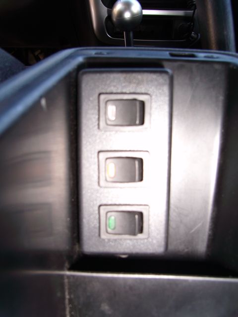 1996 Ford Probe - A set of three toggle switches are visible in the interior of a vehicle, with one switch illuminated.